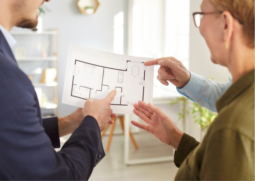 Agente immobiliare che mostra la piantina di una casa ai clienti